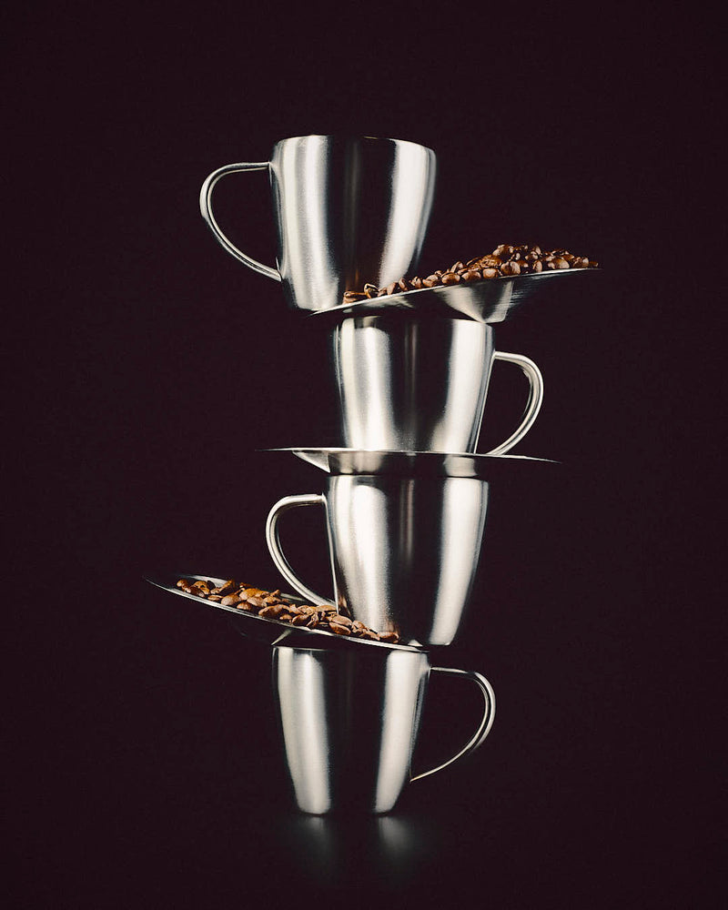 stacked metal cups with coffee beans artistic coffee setup